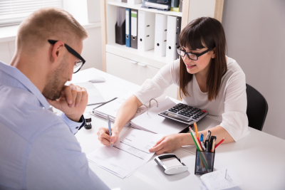 a man and a woman sitting at a white desk in an office setting